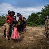 Ein Mitarbeiter des Nationalen Grenzdienstes von Panama weist eine Gruppe haitianischer Flüchtlinge ein. Nach tagelanger Dschungel-Durchquerung haben sie Quiebra Venado erreicht, die erste indigene Gemeinde auf der panamaischen Seite der Darién-Lücke