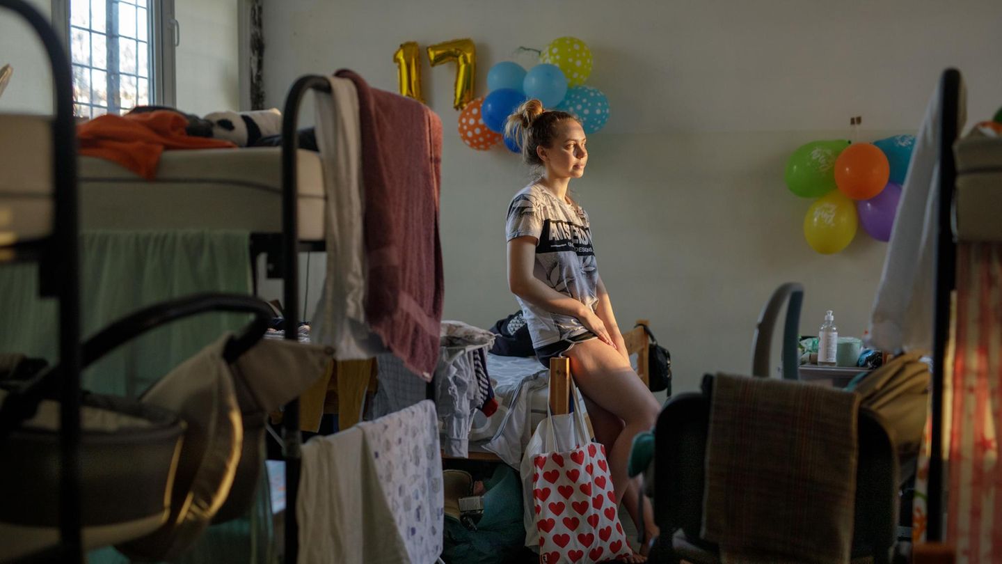 Olena lehnt an ihrem Bett, dahinter sind goldene Luftballons für den 17. Geburtstag ihrer Schwester Olena lehnt an ihrem Bett, dahinter sind goldene Luftballons für den 17. Geburtstag ihrer Schwester
