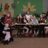 Bewohner der Unterkunft posieren an einem Tisch für ein Foto