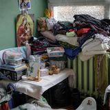 Viele persönliche Habseligkeiten, Tupperboxen, Kleidung, ein Spiegel, sind übereinander auf einen Tisch und die Heizung gestapel