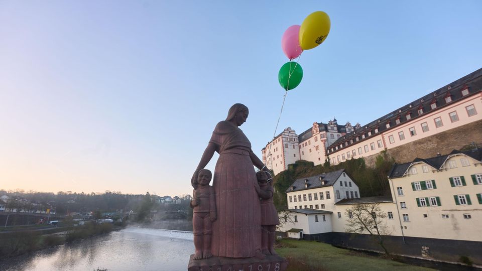 Eine Statue auf der Steinernen Brücke in Weilburg, an der Luftballons befestigt wurden