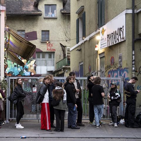 Menschen stehen bei Tagesanbruch Schlange vor einem Club