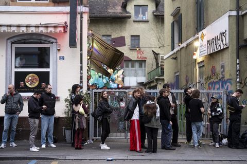 Menschen stehen bei Tagesanbruch Schlange vor einem Club