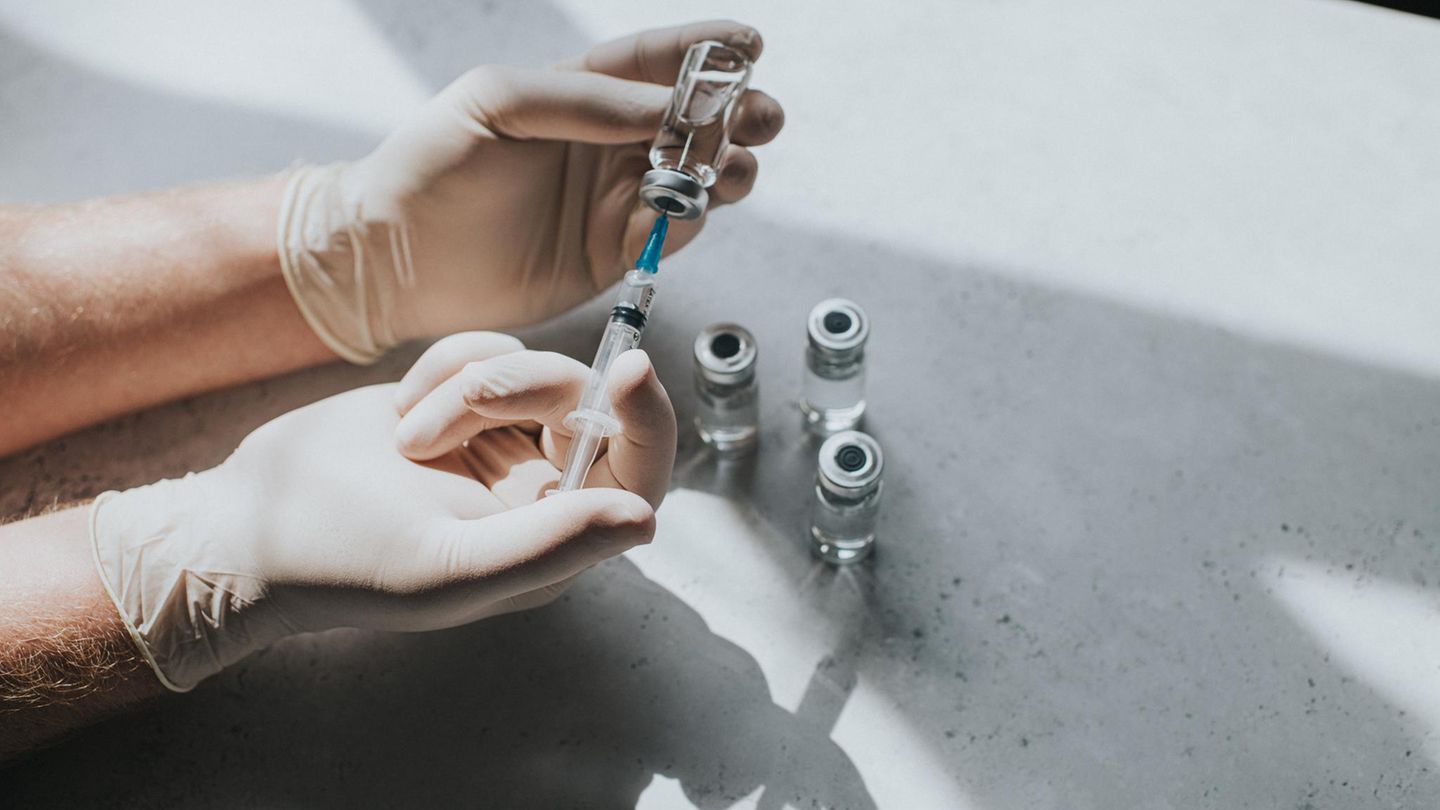 Klinikmorde Eine Hand mit Latexhandschuhen hält ein Fläschchen mit einer klaren Flüssigkeit und eine Spritze. Thema Pflege