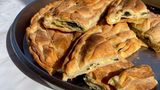 Spinatpita     "Die Spanakopita ist keine Festtagsspeise, sondern unser tägliches Brot", sagt Eleni, während sie den Filoteig hauchzart ausrollt. "Wenn die Kinder von der Schule kamen oder die Männer von den Feldern, war oft keine Zeit für aufwendige Gerichte. Aber eine Spinatpita – die konnte man schon am Morgen vorbereiten, und sie schmeckt warm genauso gut wie kalt. In den kargen Wintermonaten, wenn nicht viel auf den Feldern wuchs, war wilder Spinat unsere Rettung. Wir Frauen gingen gemeinsam sammeln, und aus dem, was die Natur uns schenkte, machten wir dieses einfache, aber nahrhafte Gericht."     Zutaten:1 kg frischer Spinat, gewaschen und grob gehackt1 Bund Frühlingszwiebeln, in feine Ringe geschnitten3 EL frischer Dill, gehackt2 EL frische Petersilie, gehackt300 g Feta-Käse, zerbröckelt3 Eier, leicht verquirlt3 EL Olivenöl, plus extra zum BestreichenSalz und frisch gemahlener schwarzer Pfeffer1 Prise frisch geriebene Muskatnuss450 g Filoteig (ca. 12-14 Blätter)100 g Butter, geschmolzen  1 EL Sesamsamen zum Bestreuen     Zubereitung:Den Backofen auf 180°C vorheizen.Den gewaschenen Spinat in eine große Pfanne geben und ohne zusätzliches Wasser bei mittlerer Hitze zusammenfallen lassen, gelegentlich wenden. In ein Sieb gießen und mit dem Rücken eines Löffels gut ausdrücken, um überschüssige Flüssigkeit zu entfernen.Den Spinat in eine große Schüssel geben und mit den Frühlingszwiebeln, Dill, Petersilie, zerbröckeltem Feta, Eiern und 3 EL Olivenöl vermischen. Mit Salz, Pfeffer und Muskatnuss abschmecken.Eine rechteckige Auflaufform (ca. 30 x 40 cm) mit etwas Olivenöl ausstreichen.Die Filoteigblätter auspacken und mit einem feuchten Tuch abdecken, damit sie nicht austrocknen.Die Hälfte der Filoteigblätter einzeln in die Form legen, jedes Blatt mit geschmolzener Butter bestreichen. Die Blätter sollten über den Rand der Form hängen.Die Spinat-Feta-Mischung gleichmäßig auf dem Filoteig verteilen.Die restlichen Filoteigblätter einzeln darüber legen, jedes Blatt wieder mit Butter bestreichen. Die überhängenden Teigränder nach innen falten und ebenfalls mit Butter bestreichen.Die Oberfläche mit einem scharfen Messer vorsichtig in Rauten- oder Quadratform einschneiden (nicht ganz durchschneiden). Mit Sesamsamen bestreuen.Im vorgeheizten Ofen ca. 45-50 Minuten backen, bis die Oberfläche goldbraun und knusprig ist.Vor dem Servieren etwa 15 Minuten abkühlen lassen und dann entlang der vorgeschnittenen Linien in Stücke schneiden.