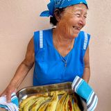 Gefüllte Paprikaschoten     "Die Gemistes sind wie unser Dorf", sagt Kyria Maria, während sie geschickt die Paprikaschoten füllt. "Von außen einfach und unscheinbar, aber im Inneren voller Überraschungen und Reichtum. Im August, wenn die Paprikaschoten in allen Farben leuchten und die Tomaten vor Reife fast platzen, duftet das ganze Dorf nach diesem Gericht. Jede Familie hat ihr eigenes Rezept, aber das Wichtigste ist die Qualität der Zutaten – sie müssen direkt aus dem Garten kommen, noch warm von der Sonne."     Zutaten:8 mittelgroße Paprikaschoten (rot, gelb und grün gemischt)250 g Rundkornreis4 reife Tomaten, gehäutet und gewürfelt1 große Zwiebel, fein gewürfelt2 Knoblauchzehen, fein gehackt50 g Pinienkerne, leicht geröstet60 ml Olivenöl, plus extra zum Beträufeln2 EL frische Petersilie, gehackt2 EL frischer Dill, gehackt1 EL frische Minze, gehackt1 TL getrockneter OreganoSalz und frisch gemahlener schwarzer Pfeffer250 ml Gemüsebrühe2 EL Tomatenpaste  1 Zitrone, in Spalten geschnitten     Zubereitung:Den Backofen auf 180°C vorheizen.Bei den Paprikaschoten den oberen Teil mit dem Stiel als "Deckel" abschneiden und beiseite legen. Die Kerne und weißen Trennwände entfernen, ohne die Schote zu beschädigen.In einer Pfanne 3 EL Olivenöl erhitzen und die Zwiebel darin glasig dünsten. Knoblauch hinzufügen und kurz mitdünsten. Die gewürfelten Tomaten zugeben und etwa 5 Minuten köcheln lassen.Den Reis, die Pinienkerne, die frischen Kräuter und den Oregano unterrühren. Mit Salz und Pfeffer würzen und alles gut vermischen. Vom Herd nehmen.Die Paprikaschoten mit der Reismischung füllen, aber nicht zu fest stopfen, da der Reis beim Kochen noch aufquillt. Die "Deckel" wieder aufsetzen.Die gefüllten Paprikaschoten in eine Auflaufform stellen. Die Tomatenpaste in der Gemüsebrühe auflösen und um die Paprikaschoten gießen. Mit dem restlichen Olivenöl beträufeln.Die Form mit Alufolie abdecken und im vorgeheizten Ofen etwa 45 Minuten backen. Dann die Folie entfernen und weitere 15-20 Minuten backen, bis die Paprikaschoten weich sind und oben leicht gebräunt.Mit Zitronenspalten servieren.  Tipps:Dazu passt perfekt Tzatziki oder Joghurt mit Paprikaöl beträufelt – hierfür Olivenöl mit etwas Paprikapulver gut verrühren.Man kann natürlich auch rote Spitzpaprika für dieses Rezept nehmen oder, auch schön, grüne und rote Paprikaschoten zusammen auf einer großen Platte anrichten!