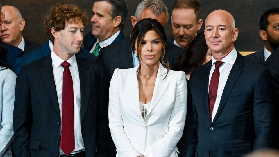 Mark Zuckerberg blickt Lauren Sanchez in den Aussxchnitt ihres weißen Anzugs