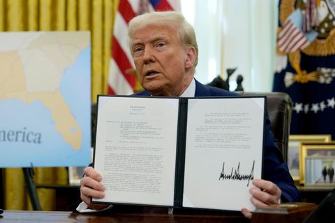 Donald Trump im Oval Office hält ein Dekret in die Kameras
