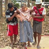 In Naypyitaw in Myanmar stützen Ersthelfer eine ältere Dame, die unter ihrem Haus eingeschlossen war