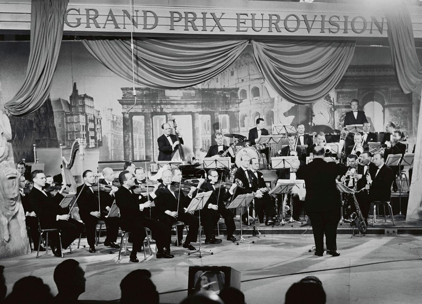 Als Mitglied der Europäischen Rundfunkunion (EBU) überträgt die ARD seit 1956 den Eurovision Song Contest, vormals Grand Prix Eurovision de la Chanson. Gleich im zweiten Jahr fand der Wettbewerb in Frankfurt am Main statt. Das Foto zeigt die Tanzorchester des Hessischen Rundfunks unter Leitung von Willy Berking (vorn stehend) im Sendesaal des Hessischen Rundfunks. Deutschland gewann den Wettbewerb bislang zweimal, 1982 mit Nicole und 2010 mit Lena Meyer-Landrut