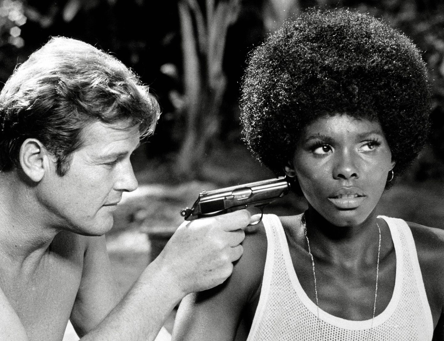 James Bond: Roger Moore alias 007 hält Gloria Hendry in "Leben und sterben lassen" eine Pistole an den Kopf