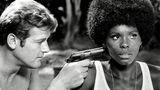James Bond: Roger Moore alias 007 hält Gloria Hendry in "Leben und sterben lassen" eine Pistole an den Kopf
