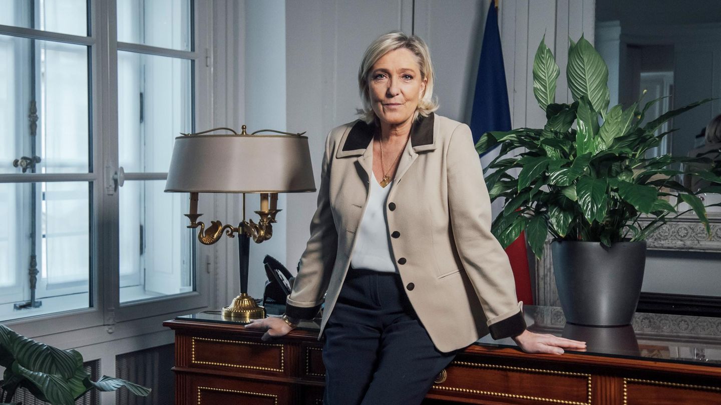 Marine Le Pen lehnt auf einem Schreibtisch