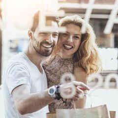 Ein Mann und eine Frau in einer Beziehung stehen vor einem Schaufenster