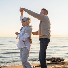 Ein älteres Paar tanzt am Strand