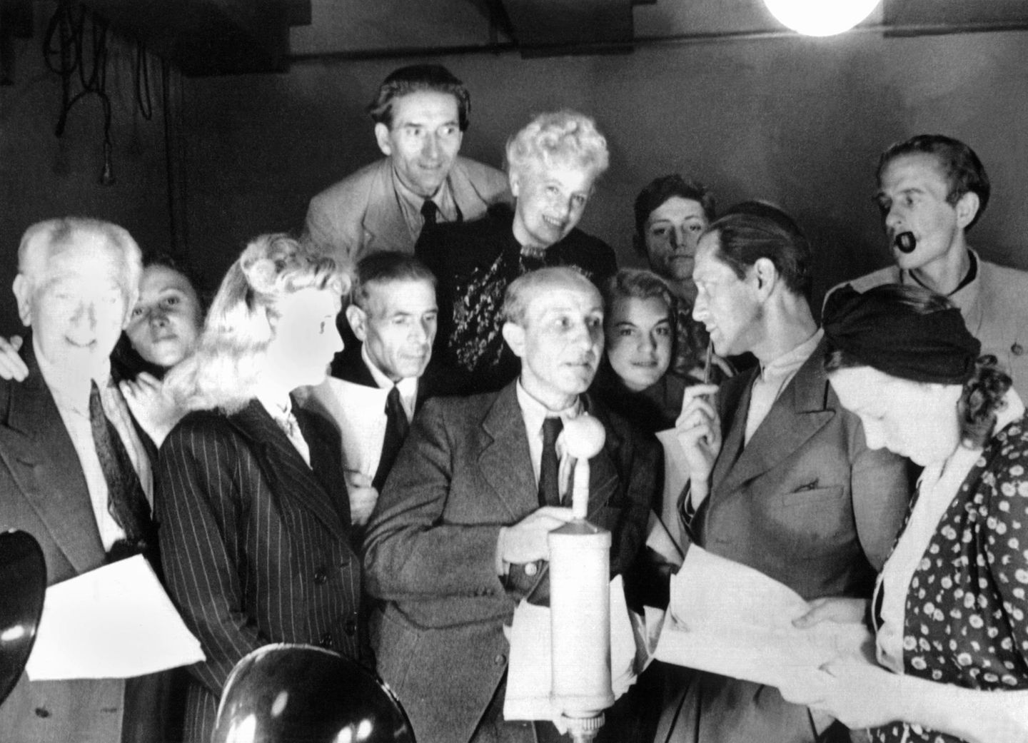 1946 ist Hans Rosenthal (4. v. r., etwas verdeckt) bereits Regieassistent beim Berliner Rundfunk. Als es zu Konflikten mit den Aufsichtsgremien der sowjetisch gesteuerten Anstalt kommt, wechselt er in den Westsektor und arbeitet fortan für den RIAS ("Rundfunk im amerikanischen Sektor"). Er wird Aufnahmeleiter, Redakteur, entwickelt und moderiert bald eigene Rate- und Unterhaltungssendungen – etwa "Das klingende Sonntagsrätsel", "Spaß muss sein", "Wer fragt, gewinnt". Ab 1955 tritt er auch als Quizmaster im Fernsehen auf. Und 1962 wird der Mann, der sich jahrelang unter Todesangst in einer Gartenlaube vor den Nazis versteckte, Unterhaltungschef beim RIAS.