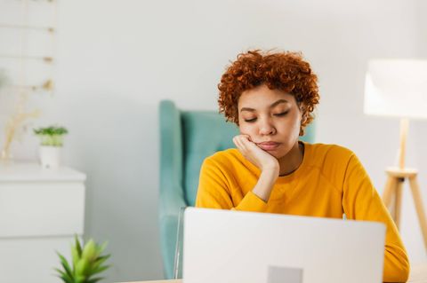 Vitamine gegen Müdigkeit: Junge Frau sitzt müde am Laptop