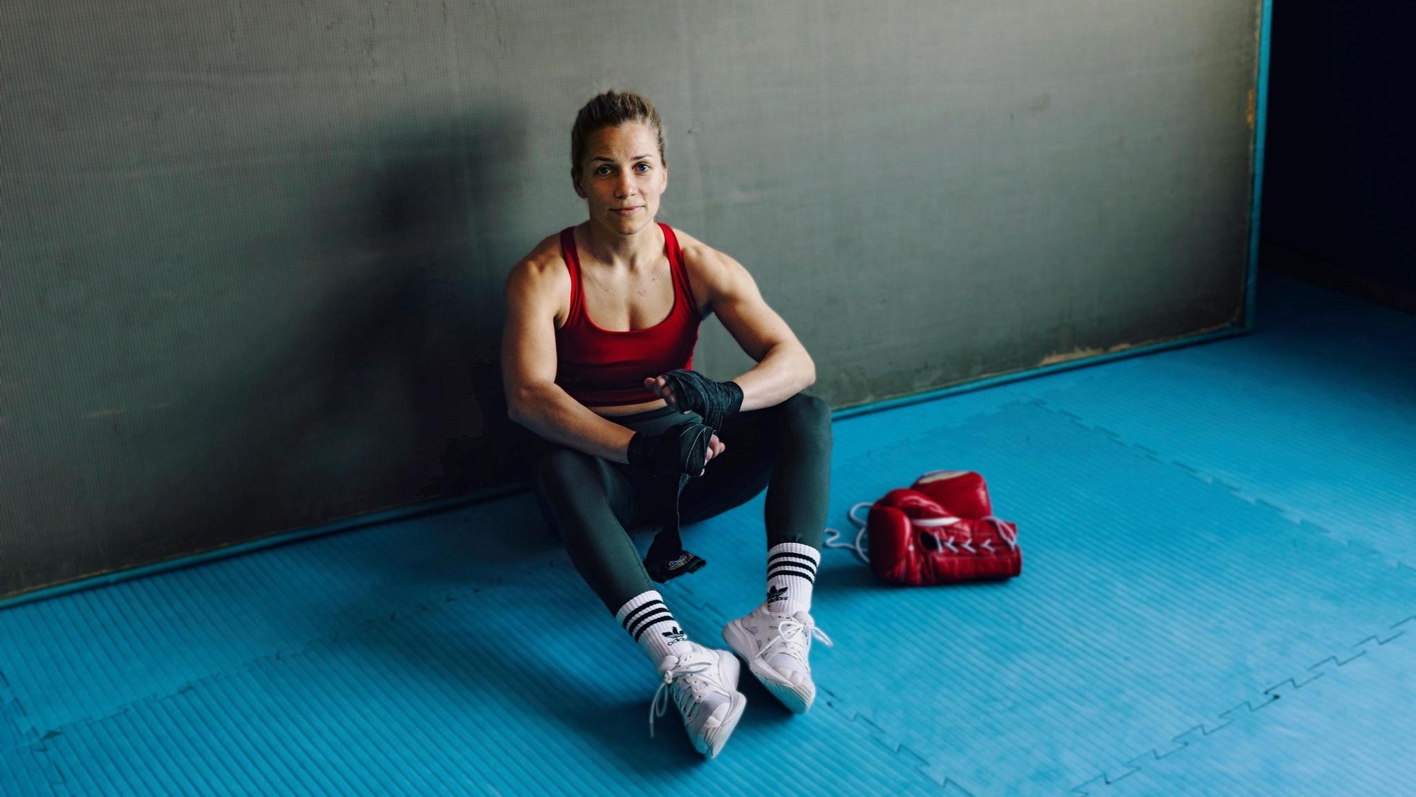Tina Rupprecht sitzt auf blauem Boden im Boxcenter Haan in Augsburg
