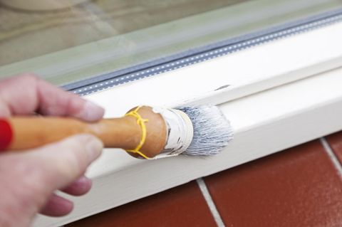 Person streicht mit Anti-Schimmel-Farbe weiß