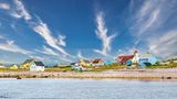 Bunte Holzhäuser stehen an einem Strand in Saint-Pierre und Miquelon