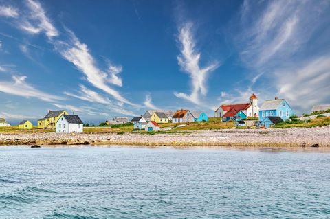 Bunte Holzhäuser stehen an einem Strand in Saint-Pierre und Miquelon