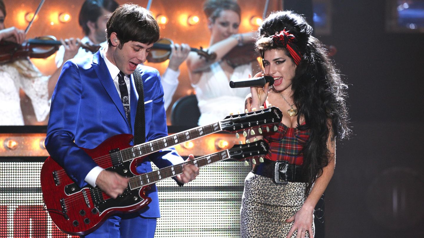 Winehouse singt 2008 bei den Brit Awards, links neben ihr spilet ihr Produzent Mark Ronson Gitarre