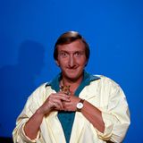 Mike Krüger grinst und hält einen Hamster in den Händen