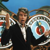 Rudi Carrell im schwarzen Sakko in der Show "Am laufenden Band", er gestikuliert mit den Händen