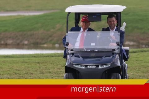 Eric Trump und Donald Trump sitzen in einem Golfkart