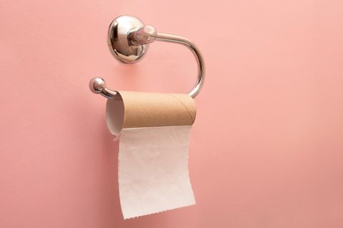 Symbolbild Angststörung Einnässen: Vor einem rosafarbenen Hintergrund hängt eine fast leere Klopapierrolle an einer Halterung