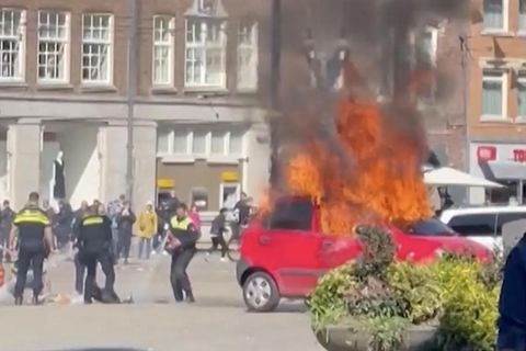 Auf dem Platz Dam in Amsterdams Zentrum nahe des Palastes brennt ein Auto lichterloh
