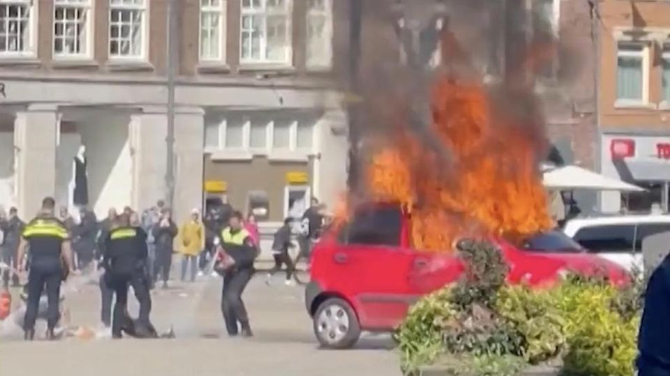 Auf dem Platz Dam in Amsterdams Zentrum nahe des Palastes brennt ein Auto lichterloh