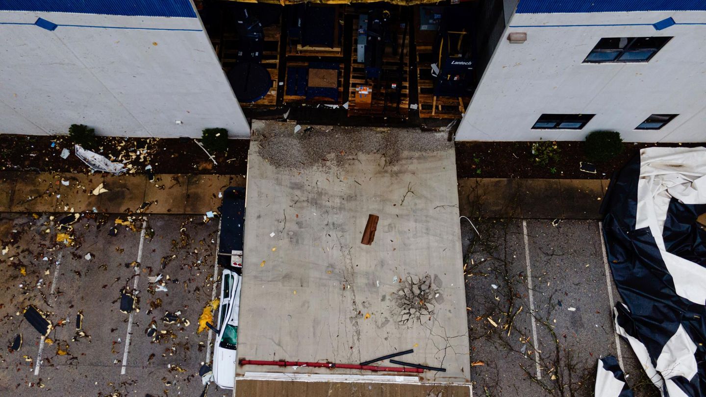 USA, Selmer:Eine Fabrikwand liegt nach dem Unwetter herausgebrochen auf der Straße. Am Rand ist ein zerstörtes Auto zu erkennen