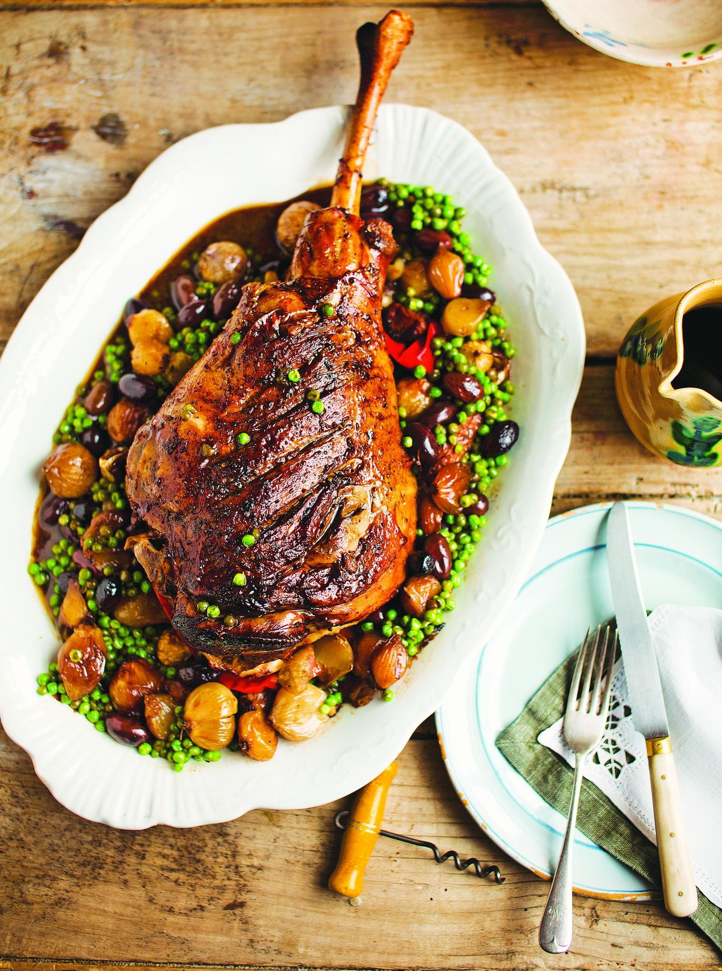 Gebratene Lammkeule mit Erbsen und Perlzwiebeln (Cosciotto d'agnello con piselli e cipolline)     Für 4 Personen  ½ Lammkeule (1,2 kg)  Salz und schwarzer Pfeffer aus der Mühle  etwas natives Olivenöl extra  150 ml trockener Weißwein  300 g Perlzwiebeln oder Schalotten  24 Taggiasca-Oliven (aus dem italienischen Feinkostladen), entsteint  2 Knoblauchzehen, leicht zerdrückt  4 Sardellenfilets, grob gehackt  150 g TK-Erbsen     Für einen besonderen Anlass oder als Sonntagsbraten ist dieses Gericht einfach perfekt. Die Kombination aus Perlzwiebeln, schwarzen Oliven, Sardellen, Knoblauch und Erbsen passt wunderbar zum saftigen Lammfleisch. Die Taggiasca-Oliven können Sie durch griechische Kalamata-Oliven ersetzen, die dem Gericht ein leicht säuerliches Aroma verleihen.  Den Backofen auf 200 °C vorheizen. Das Lammfleisch rundum mit Salz, Pfeffer und Olivenöl einreiben. In eine Bratreine legen und 20 Minuten im Ofen braten.  Die Hälfte des Weins zugießen und weitere 20 Minuten garen. Restlichen Wein, Perlzwiebeln, Oliven, Knoblauch und Sardellen zugeben, mit Alufolie abdecken und 70 Minuten schmoren.  Die Erbsen zufügen und 10 Minuten garen. Die Alufolie abnehmen und das Fleisch weitere 10 Minuten braten.  Aus dem Backofen nehmen und 5 Minuten ruhen lassen. Die Lammkeule auf einem Schneidebrett tranchieren und mit Gemüse und Bratensaft servieren