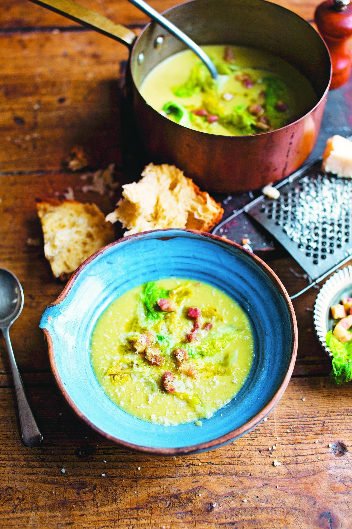 Suppe aus Schälerbsen und Gartensalat (Zuppa di piselli secchi con lattuga)     Für 4 Personen  300 g getrocknete halbe Schälerbsen  2 EL natives Olivenöl extra  50 g Butter  1 kleine Zwiebel, in Scheiben geschnitten  1 Staudensellerieherz, gehackt  85 g Pancetta, gewürfelt  2 Kartoffeln, grob gewürfelt  1 l heiße Gemüsebrühe  250 g Gartensalat  225 ml Milch  2 Bio-Eigelb, verquirlt  geriebener Parmesan zum Servieren     Diese wunderbar altmodische Suppe stammt noch aus der Zeit, als es keine tiefgekühlten Erbsen gab: Italienische Hausfrauen hatten immer getrocknete halbe Erbsen im Vorrat, die sie zubereiteten, wenn frische Erbsen keine Saison hatten. Die gekochten Erbsen sind ziemlich fest. Zum Ausgleich habe ich die Kartoffeln und den Pancetta in grobe Stücke geschnitten und die Suppe nicht püriert. Wer will, kann sie aber pürieren und erst danach die Milch-Ei-Mischung zugeben. Durch den Gartensalat erhält sie ein frisches Aroma. Schälerbsen muss man nicht einweichen, aber lesen Sie besser die Packungsanweisung durch.  Die halben Erbsen unter fließendem kalten Wasser abspülen und säubern. Danach beiseitestellen. Das Olivenöl und die Hälfte der Butter in einem großen Topf bei mittlerer Stufe heiß werden lassen. Zwiebel, Staudensellerie und Pancetta zufügen und 5 Minuten anschwitzen, bis das Gemüse weich ist. Kartoffeln und Schälerbsen unterrühren. Brühe und 500 ml heißes Wasser zugießen, einen Deckel auflegen und bei niedriger Hitze 1 ½ Stunden garen. Gelegentlich umrühren, damit die Erbsen nicht anhaften.  Die Salatblätter 15 Minuten vor dem Ende der Garzeit in einen Topf mit kochendem Wasser legen und 6 Minuten blanchieren. Abseihen, Wasser ausdrücken und die Blätter abkühlen lassen. Längs in feine Streifen schneiden und beiseitestellen.  Die restliche Butter zerlassen und mit Milch und Eigelb in einer Schüssel verquirlen. Die Suppe vom Herd nehmen, die Milch-Ei-Mischung einrühren, mit den Salatstreifen und dem Parmesan bestreuen und servieren