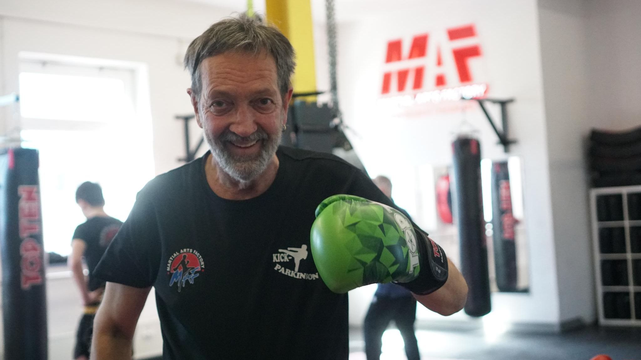 Parkinson: Carsten Köpcke steht mit Boxhandschuhen in einer Sporthalle