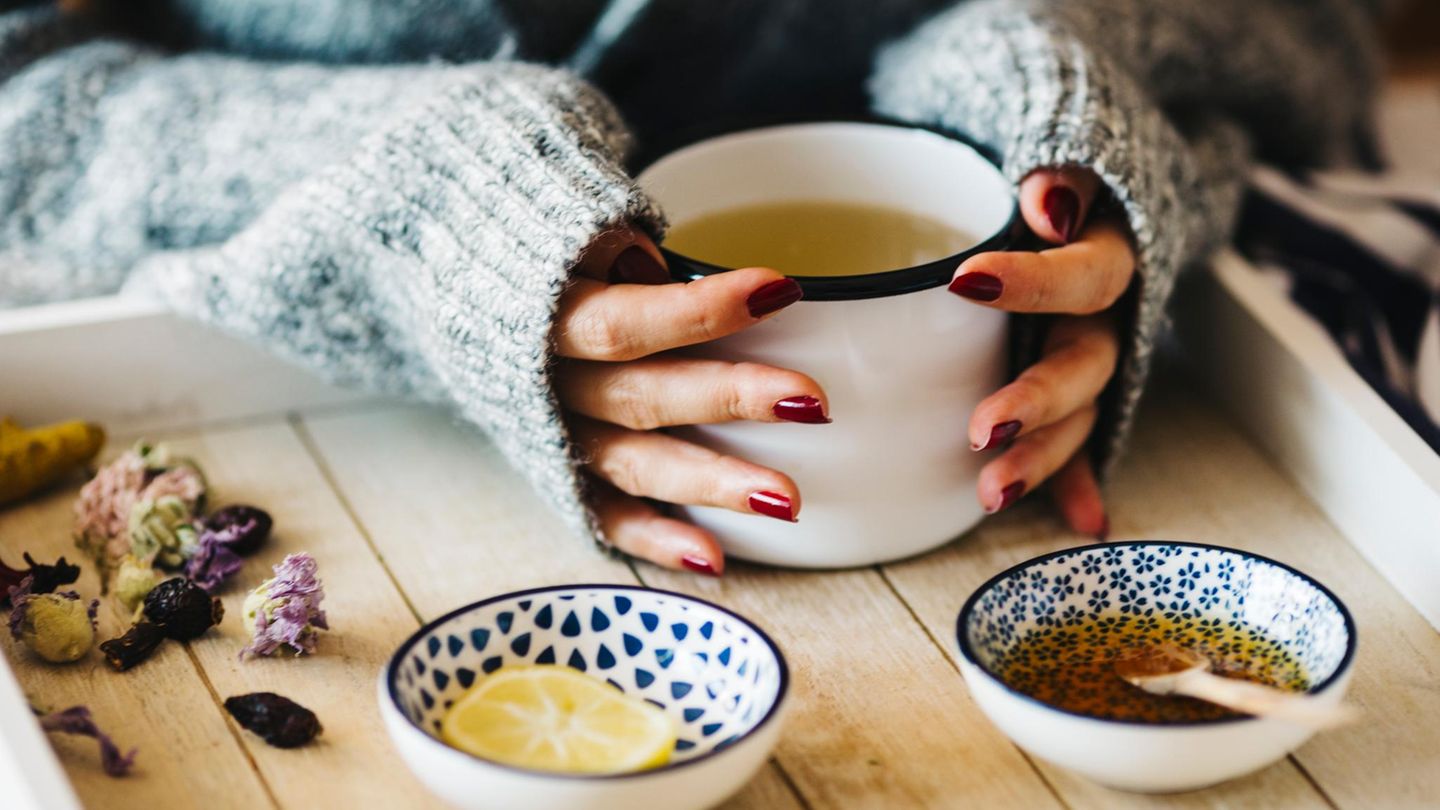 Ostern-Völlerei: Hände umfassen Teetasse