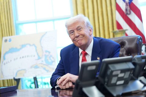 US-Präsident Donald Trump sitzt im Oval Office und grinst schelmisch und zufrieden
