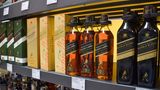 In einem Regal stehen Whiskey-Flaschen von Johnny Walker, einer Diageo-Marke