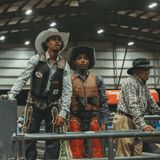 Cowboys schauen einem Kandidaten beim Bullenreiten zu – einem der gefährlichsten Wettbewerbe bei klassischen Rodeos. Der Reiter muss sich mindestens acht Sekunden auf dem Rücken des unwilligen Bullen halten, während dieser ihn abzuschütteln versucht