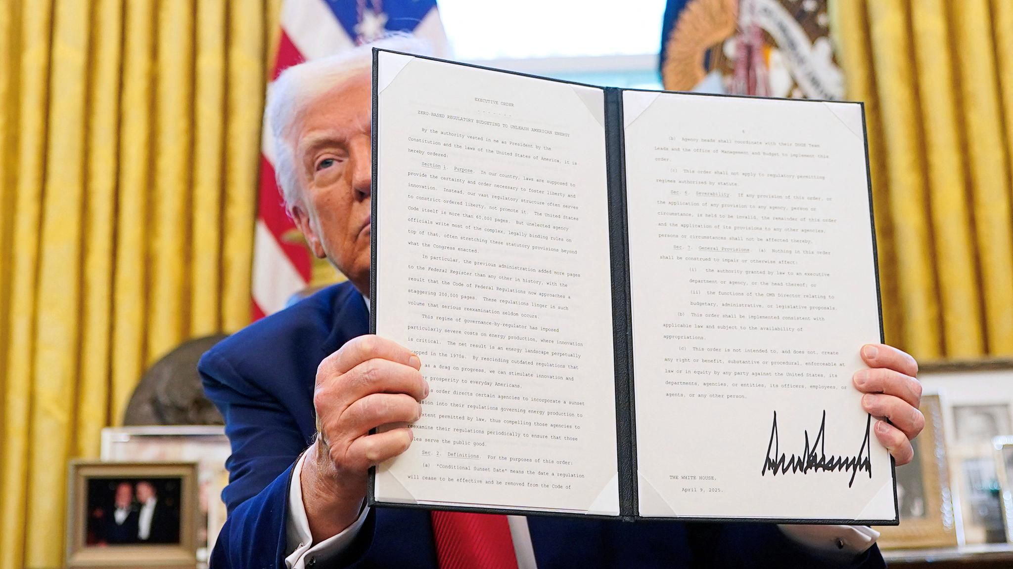 Präsident Donald Trump hält eine unterzeichnete Exekutivanordnung empor