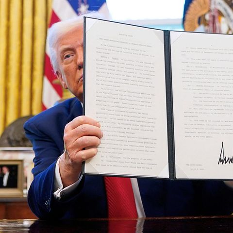 President Donald Trump holds up an signed executive arrangement