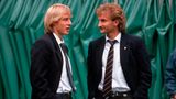 Jürgen Klinsmann und Rudi Völler treffen sich in Italien, beide tragen einen schwarzen Anzug.