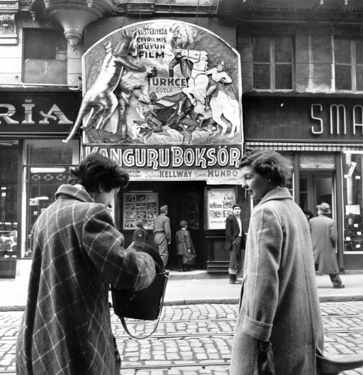 Zwei Sekretärinnen des britischen Generalkonsulats in Istanbul vor einem Kino. Atatürk sieht den Westen als Inbegriff des Fortschritts. Er und seine Nachfolger richten die Türkei radikal an den Idealen der europäischen Aufklärung aus, drücken Reformen und Modernisierungen kompromisslos durch. Ankara sucht nicht zuletzt aus wirtschaftlichen und sicherheitspolitischen Gründen den Anschluss an Europa und die USA, tritt 1952 der NATO bei