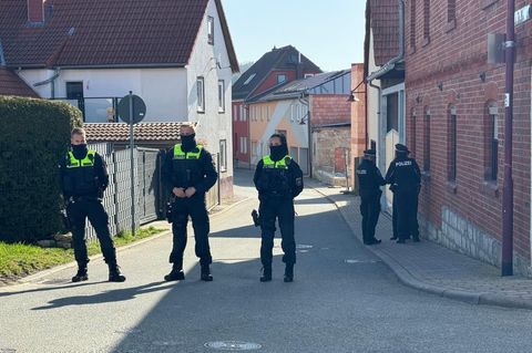 Polizisten stehen auf einer Straße in Klettbach, Thüringen