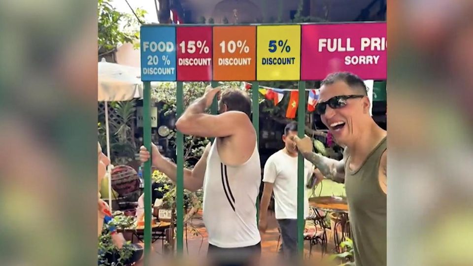 "Deutscher Biergarten" wirbt mit skurriler Rabattaktion Touristen versuchen sich zwischen möglichst schmalen Gittern durch zu quetschen