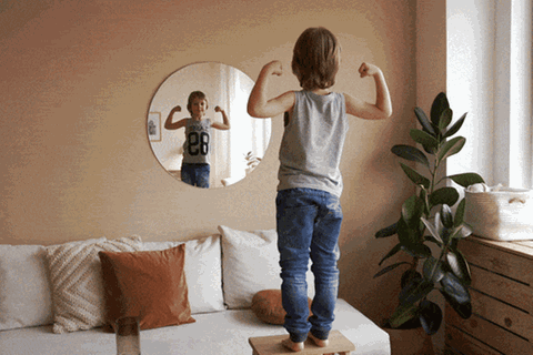 Ein Sohn posiert vor einem Spiegel wie ein kleiner Macker ohne angemessene Erziehung