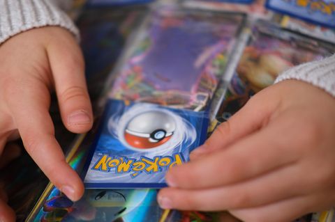 Jemand schiebt eine Pokémon-Karte in einen Sammelordner
