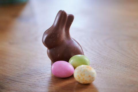 Ein ausgepackter Osterhase aus Schokolade und Schokoladeneier auf einem Tisch