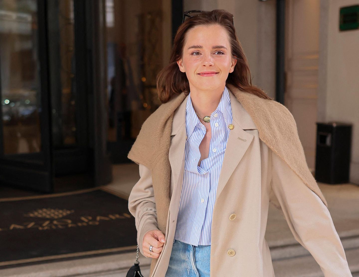 Emma Watson in hellem Trenchcoat und Sonnenbrille im Haar in Mailand